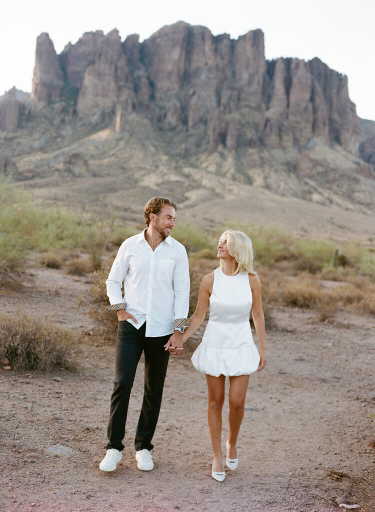 Romantic Arizona engagement photo with couple walking in desert landscape