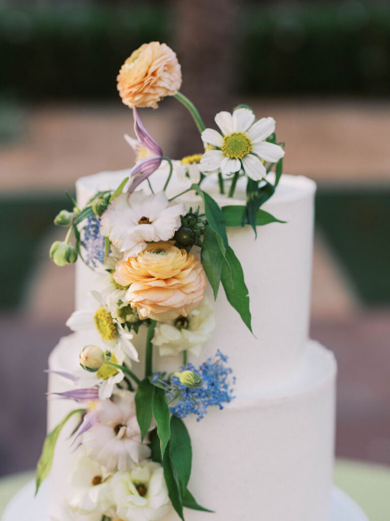 White wedding cake decorated with fresh pastel florals