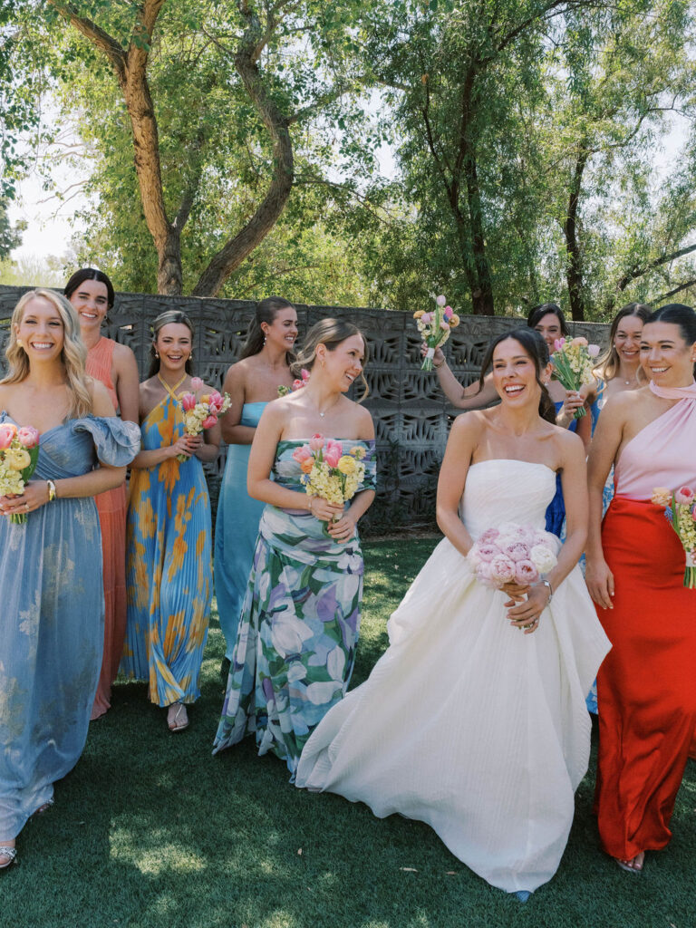 Bride smiling with bridesmaids in colorful dresses Arizona wedding