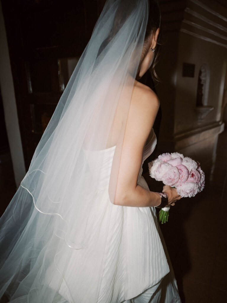 Bride with flowing veil holding bouquet luxury Arizona wedding