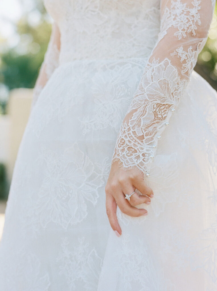 Bride’s lace gown sleeve and wedding ring detail in Arizona.