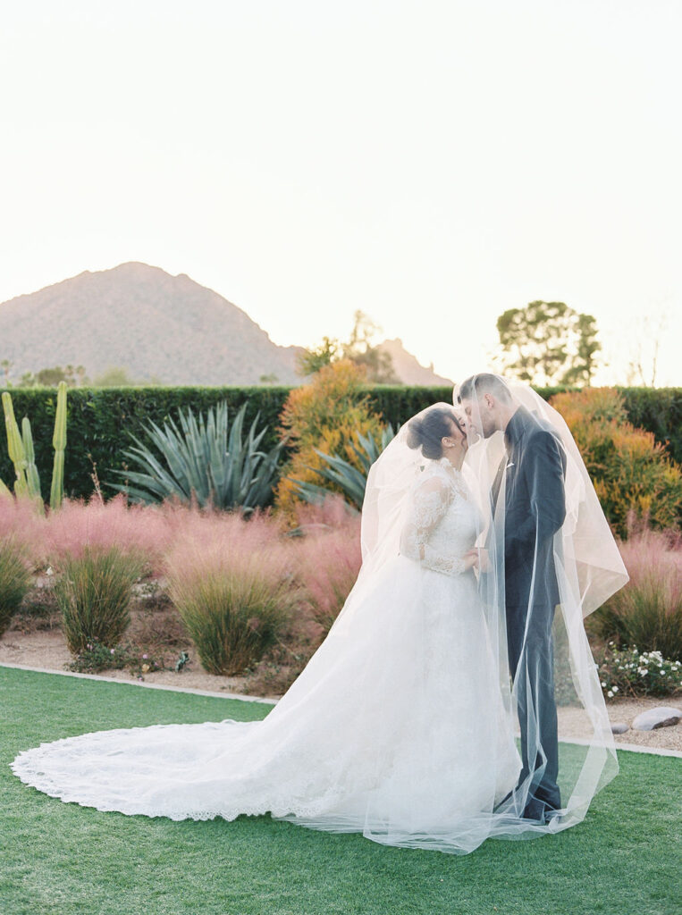 Bride and groom kissing outdoors in Scottsdale desert light.