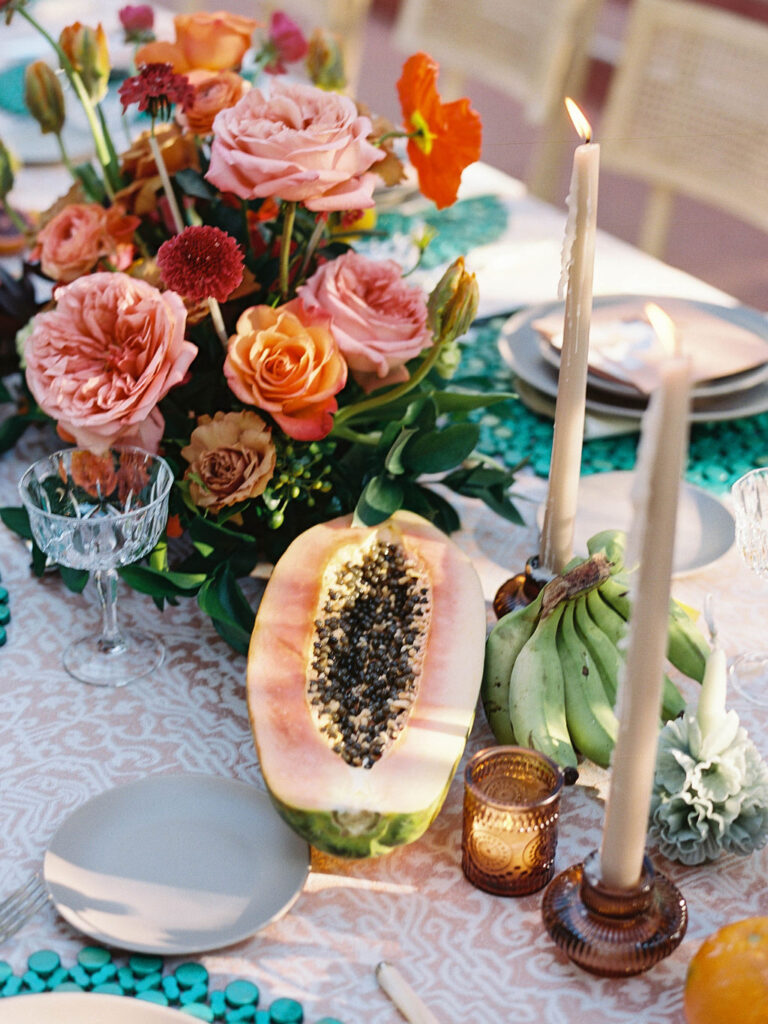 Papaya and floral wedding reception centerpiece at El Chorro.