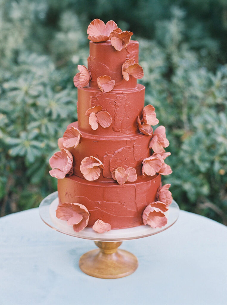 Coral wedding cake with floral accents at El Chorro reception.