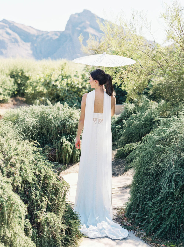 Bride holding parasol in Camelback Inn garden setting