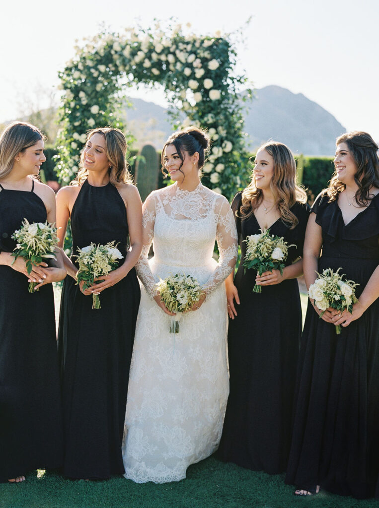 Bride and bridesmaids in black gowns holding bouquets in Arizona.