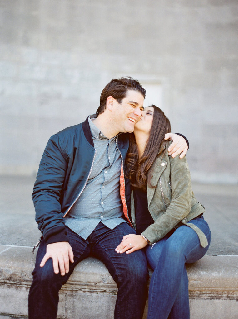 Couple sitting close and laughing during NYC engagement session