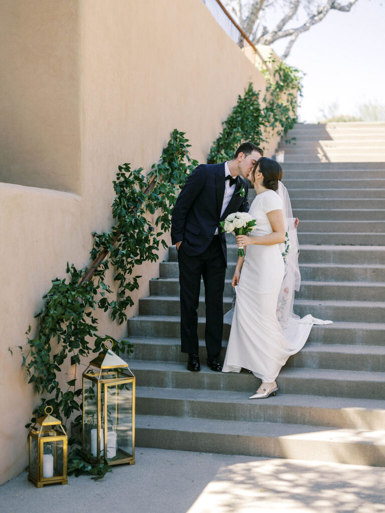 Bride and groom walking down floral-decorated staircase