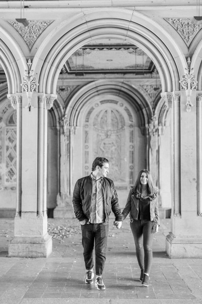 Couple walking hand-in-hand under Bethesda Terrace arch
