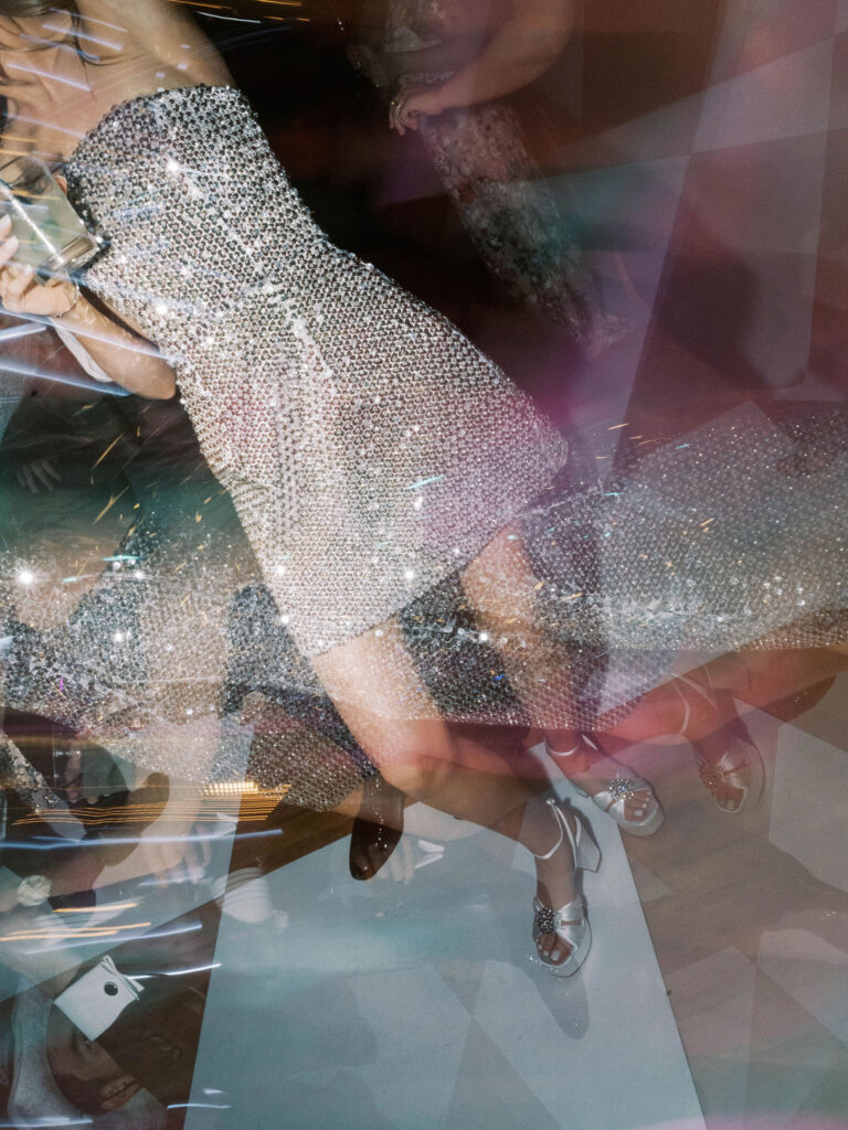Guest dancing in sequined dress with motion blur.