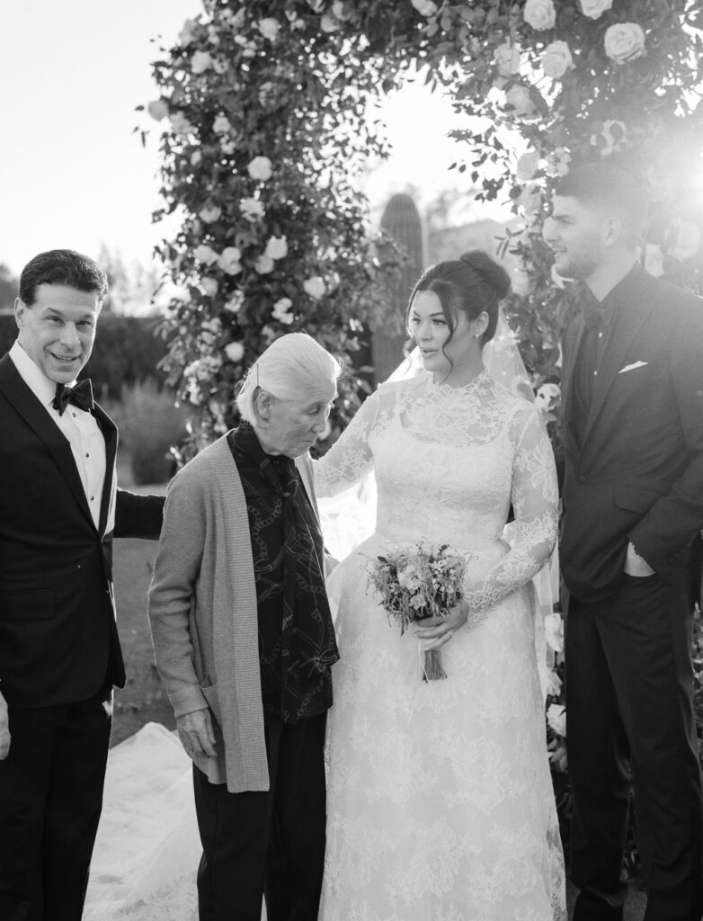Bride hugging family member after ceremony in black and white.