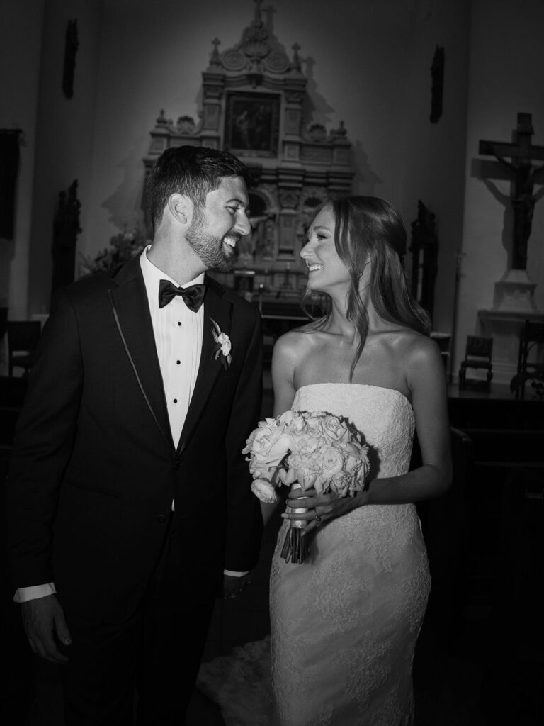 Black and white portrait of bride and groom smiling.