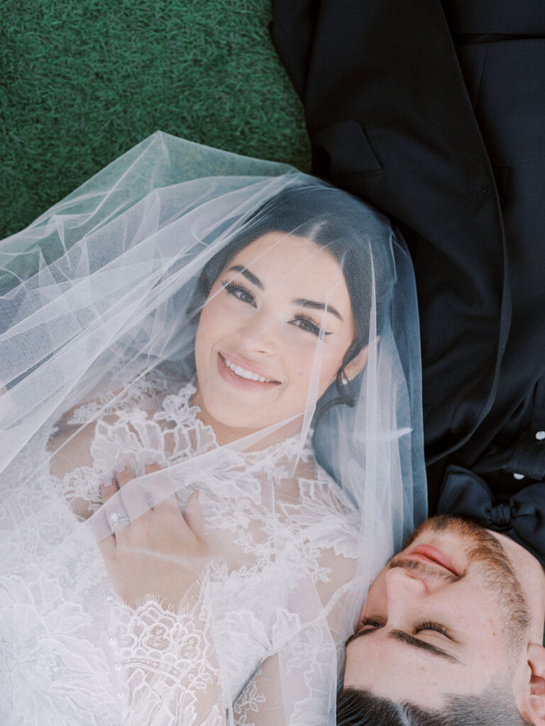 Bride smiling under veil during Arizona wedding.