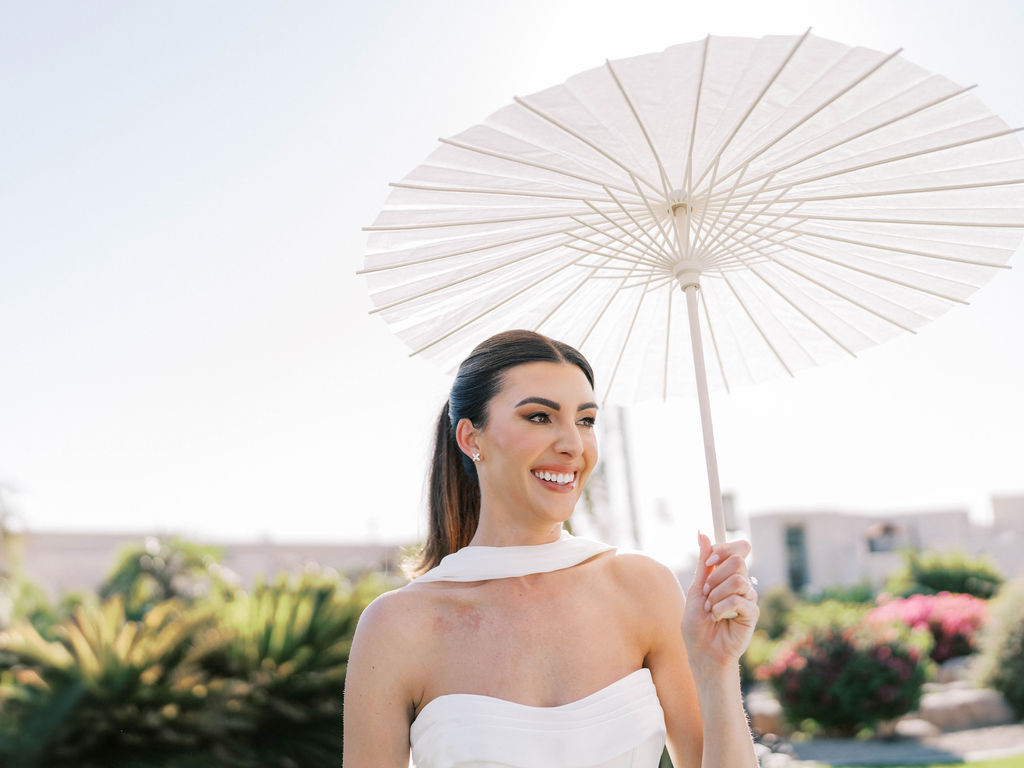 Bride holding parasol at Camelback Inn garden wedding
