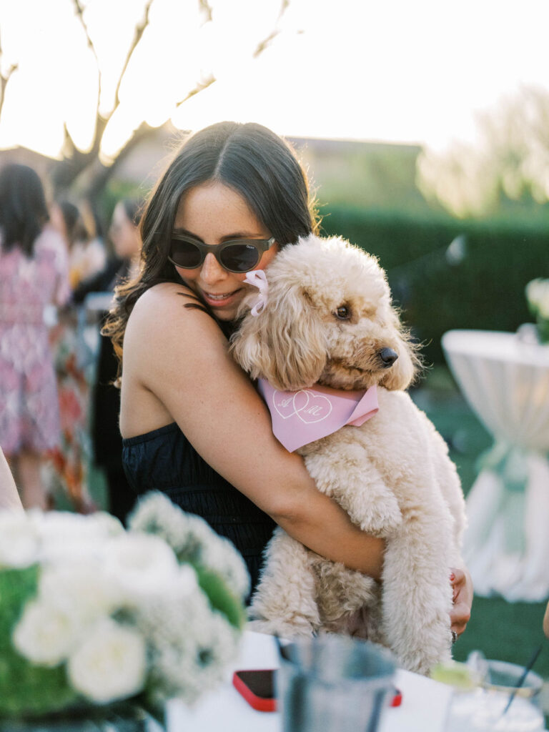 Guest holding fluffy dog at Silverleaf Arizona wedding welcome party