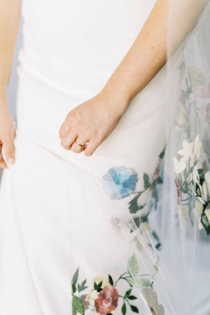 Bride showing ring with floral gown details at Arizona wedding