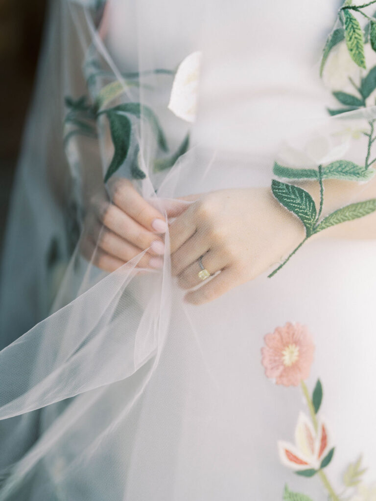 Close-up of bride’s hand with floral veil detail at DC Ranch