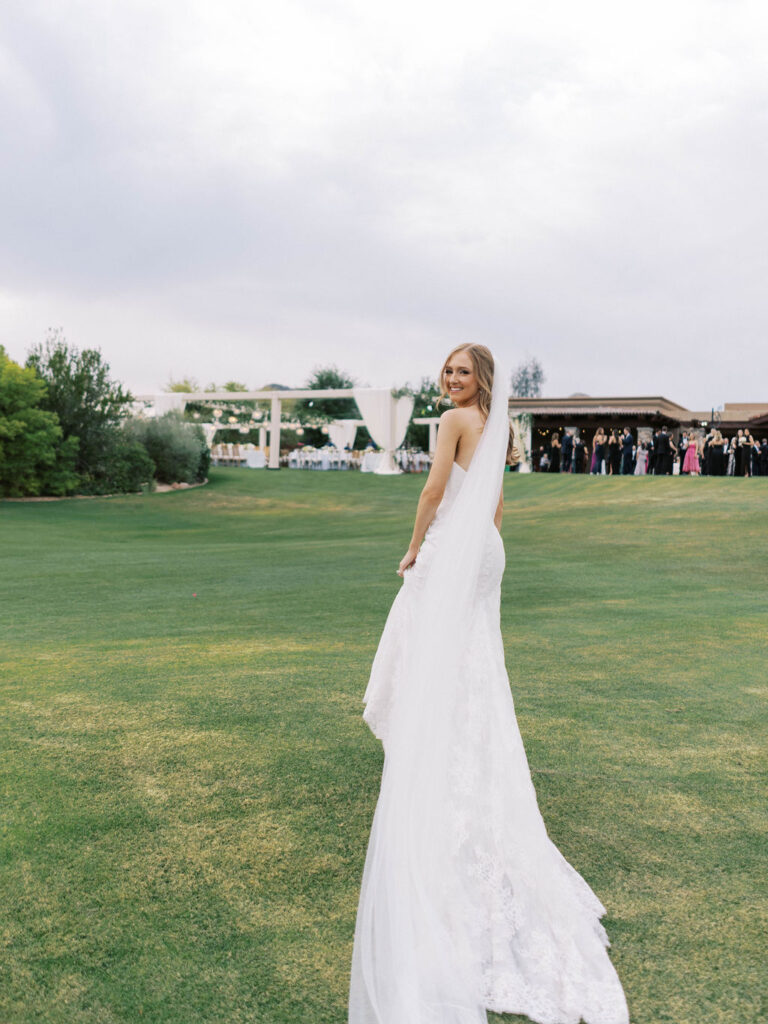 Bride smiling on expansive Paradise Valley Country Club lawn.