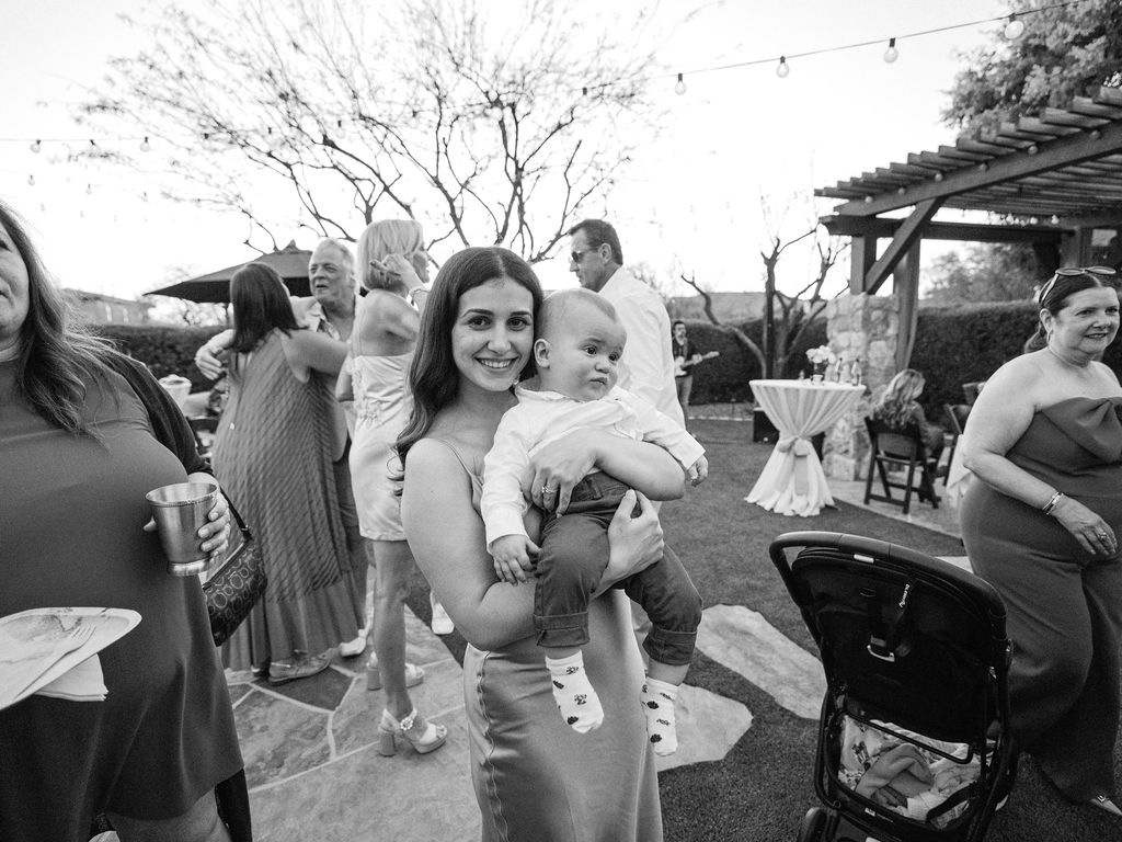 Arizona wedding guest holding baby during Silverleaf Masters Golf welcome party