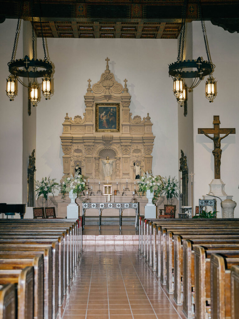 Elegant altar view inside Brophy Chapel with floral wedding design.