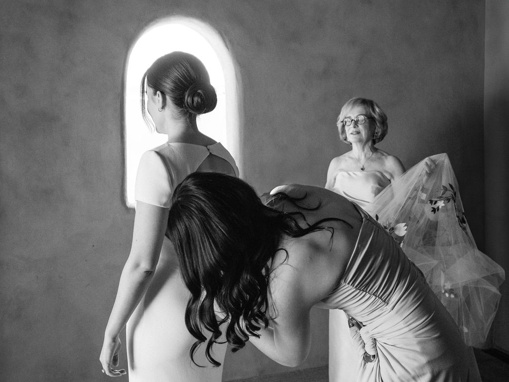Bride hugging bridesmaid in candid black and white photo