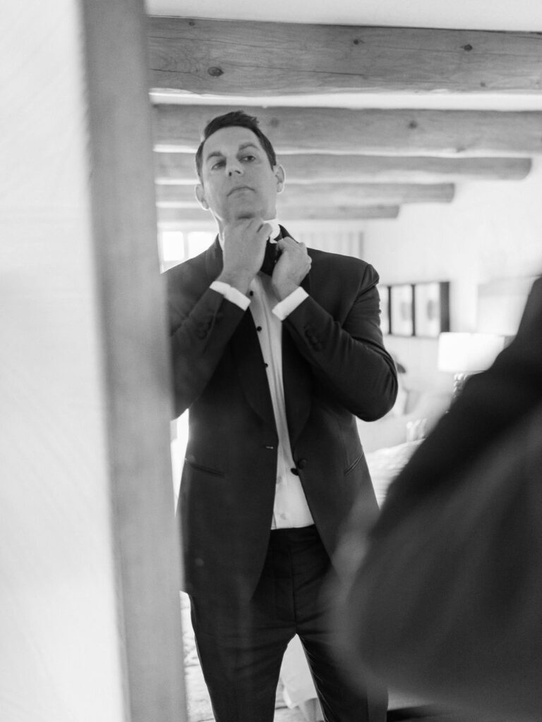 Groom adjusting his tie before wedding ceremony at Camelback Inn