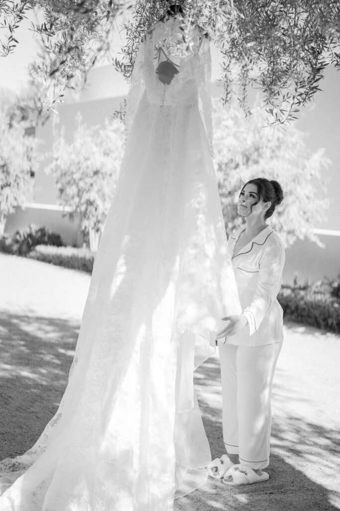 Black and white photo of bride under veil before ceremony.