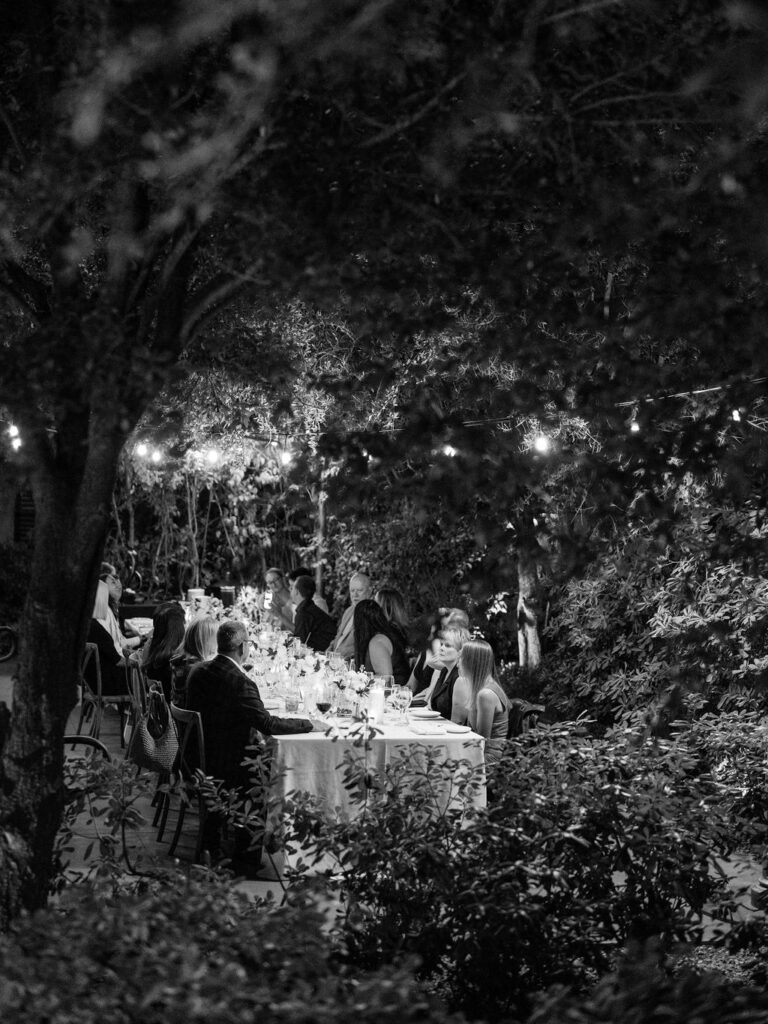 Black and white wide view of dinner table under string lights at El Chorro