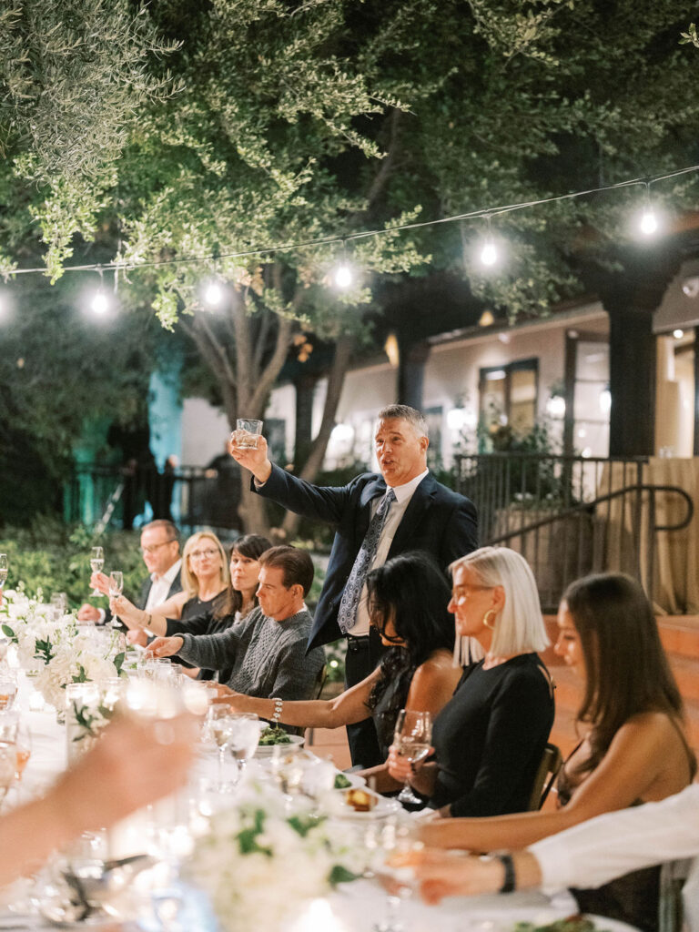 Long dinner table toast at El Chorro under string lights