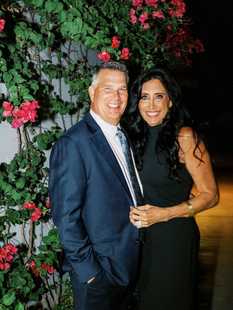 Couple portrait at El Chorro dinner party against floral backdrop