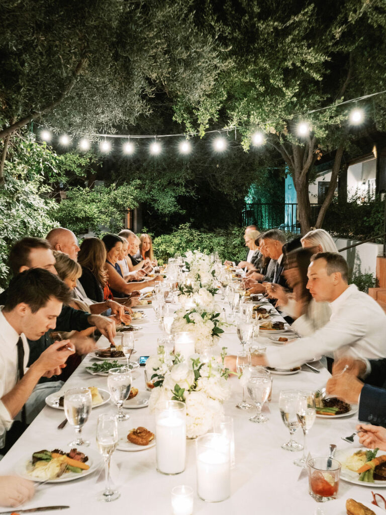 Guests at long dinner table under string lights at El Chorro