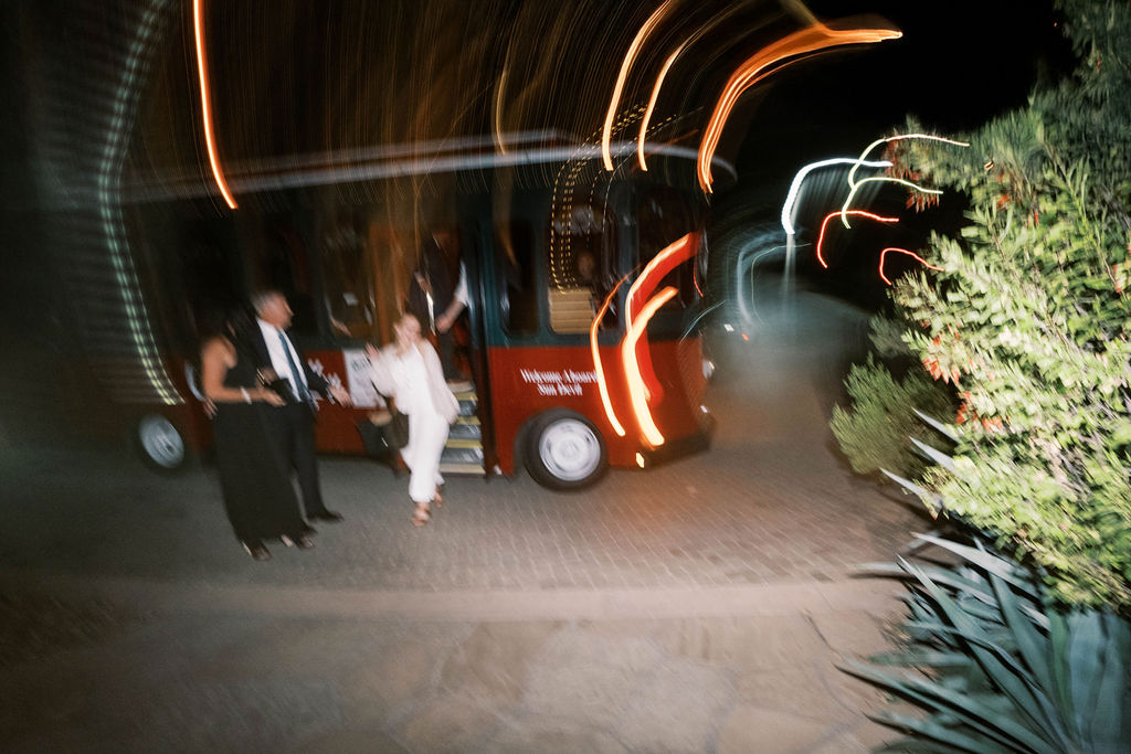 Newlyweds leaving El Chorro dinner party with wedding trolley at night