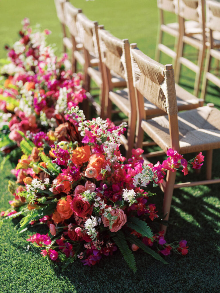 Colorful aisle floral arrangements for outdoor ceremony at El Chorro.