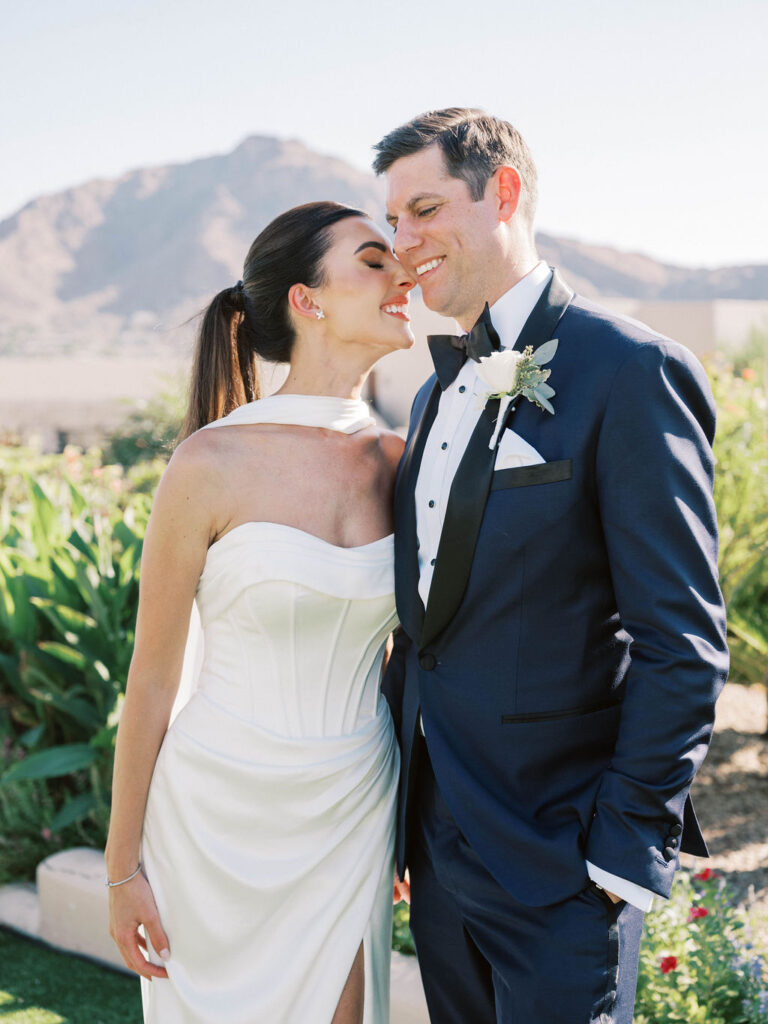 Bride and groom sharing a romantic embrace with Camelback Mountain views