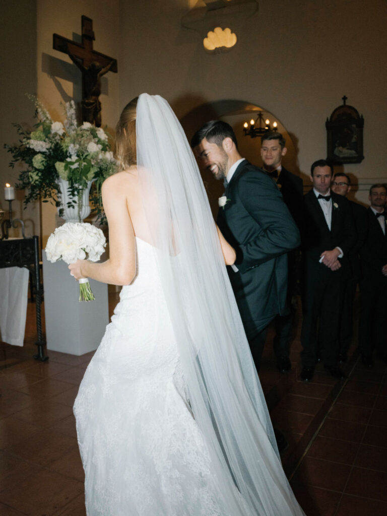 Bride and groom walking together inside Brophy Chapel.
