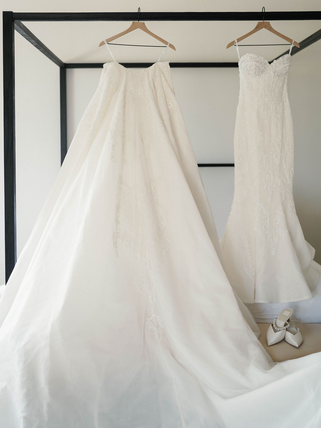 Two bridal gowns hanging from canopy bed at Four Seasons Resort casita