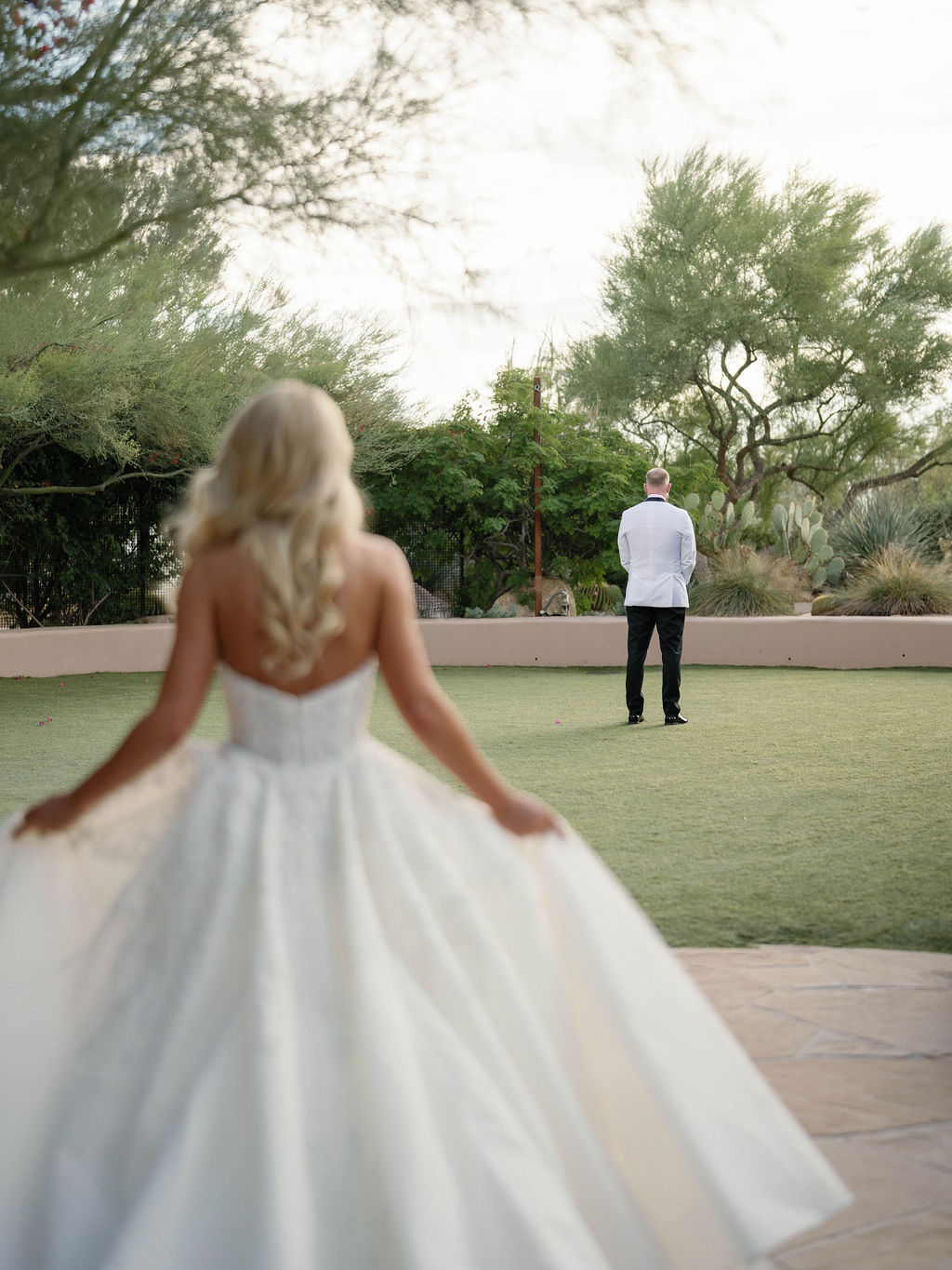Bride approaching groom for first look in the Sonoran Desert at Four Seasons Scottsdale