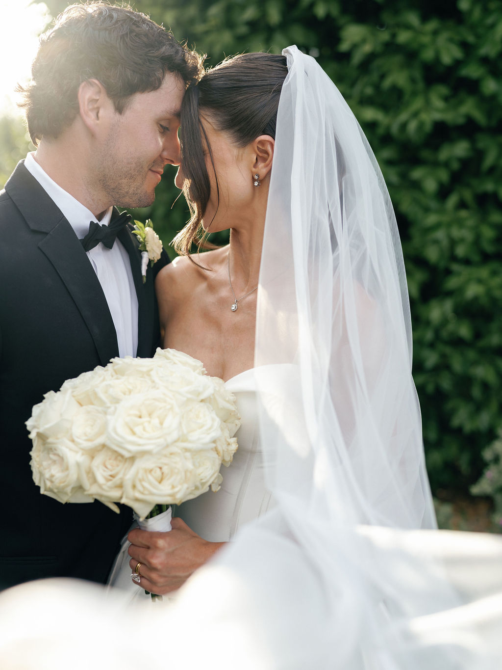 Bride and groom portrait with cathedral veil and white rose bouquet at El Chorro
