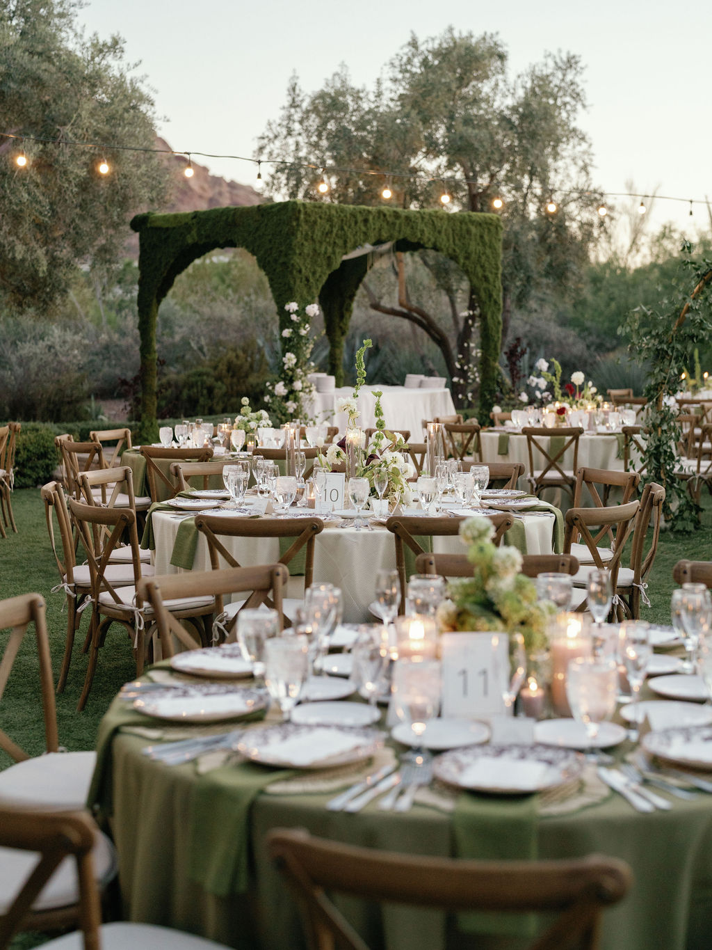 Candlelit reception scene beneath the moss arch