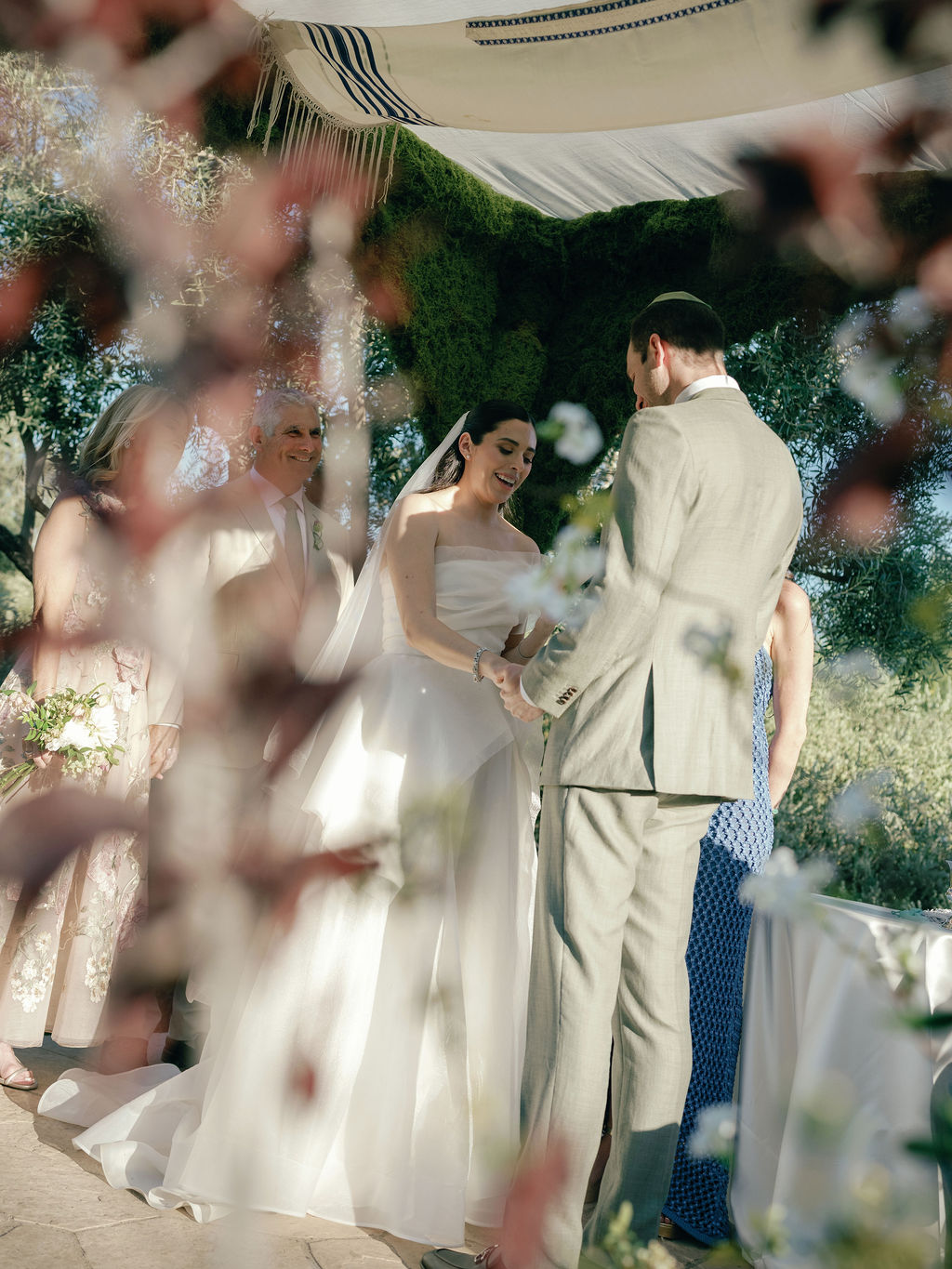 Ceremony beneath the chuppah, florals in the foreground