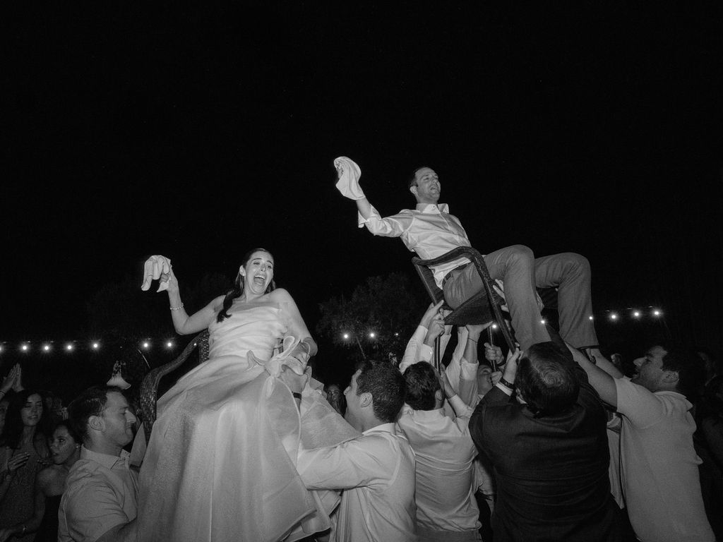 Guests lifting the newlyweds during the hora