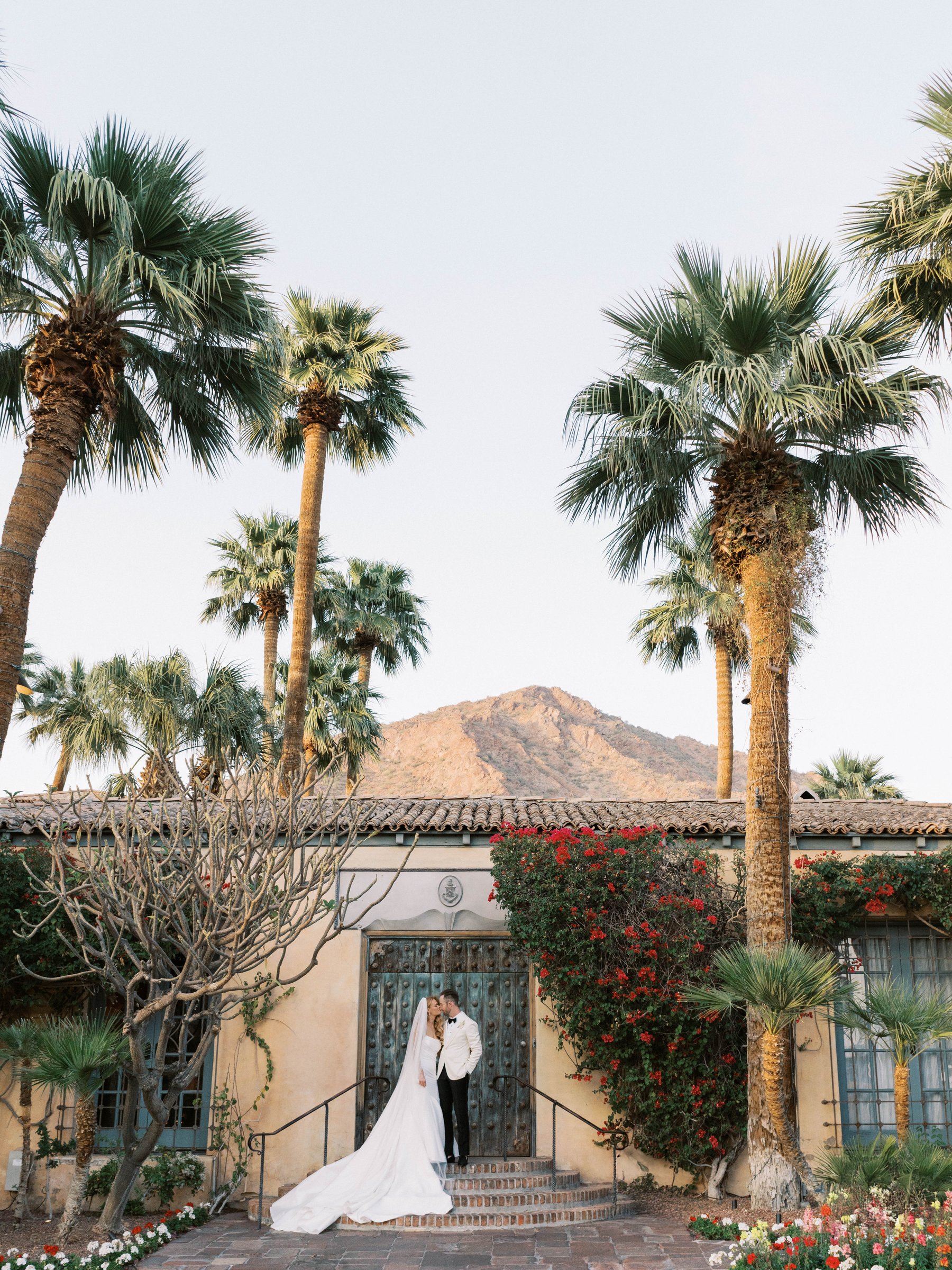 Meg and Peter beneath the palms with Camelback Mountain beyond Royal Palms