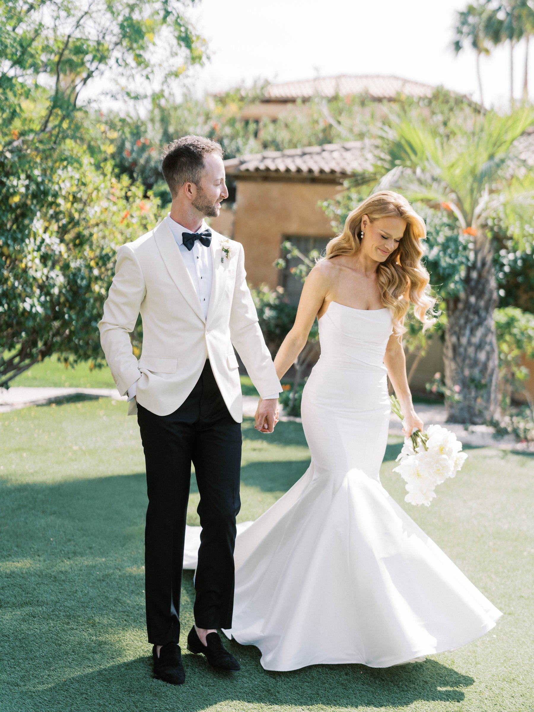Meg and Peter walk hand in hand through the Royal Palms garden