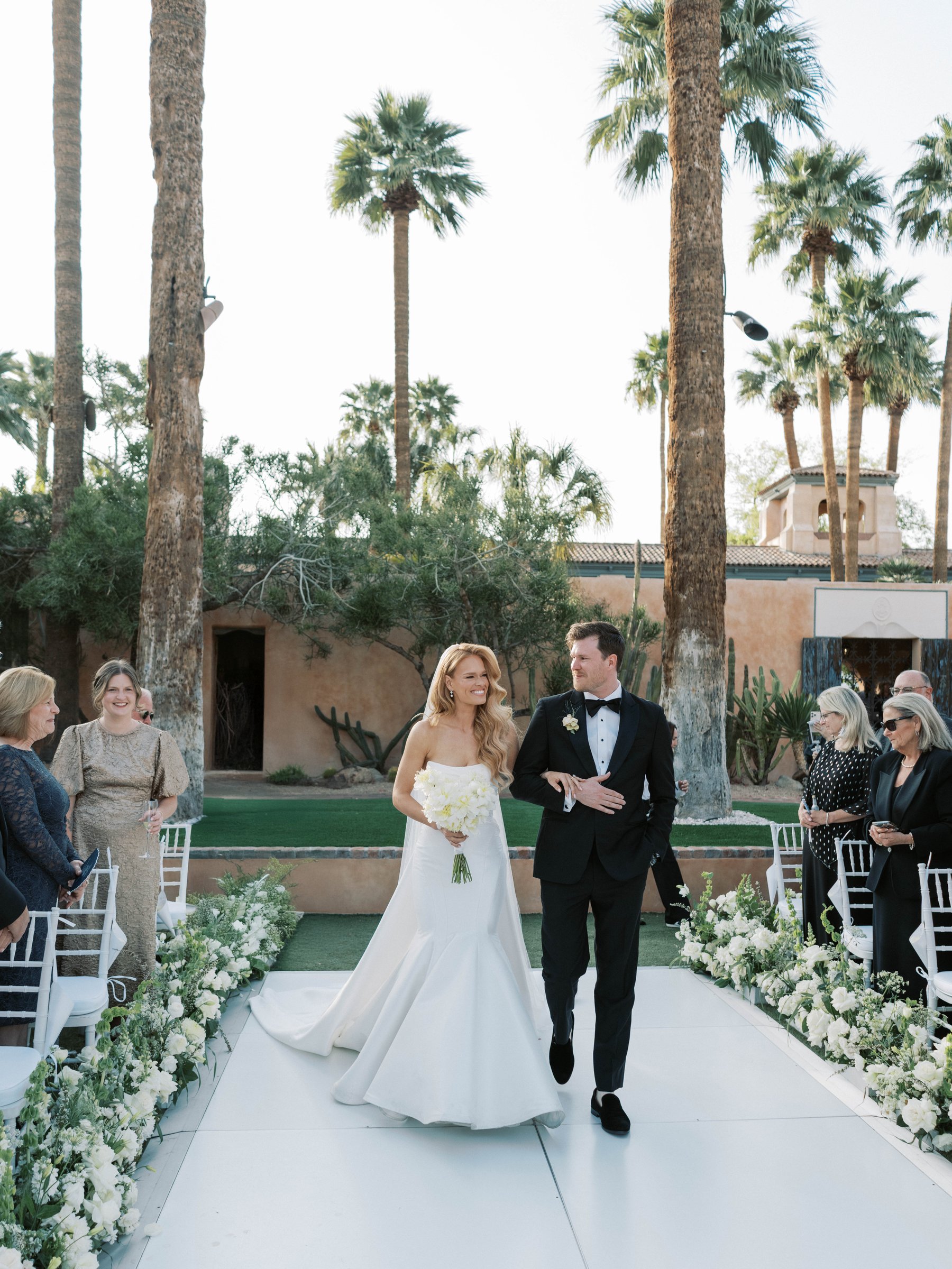 Meg walks down the garden ceremony aisle with a family member