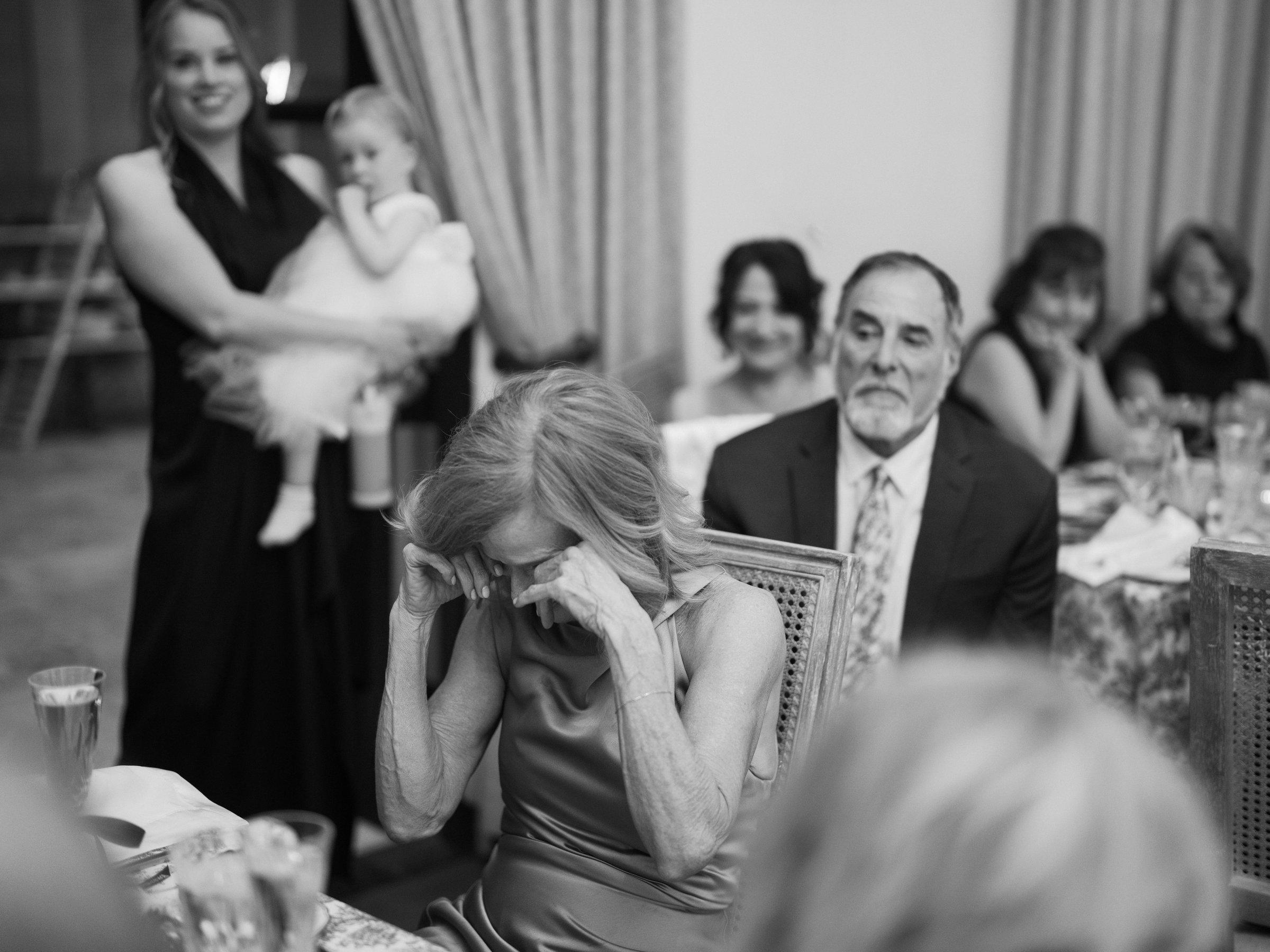 A guest wipes away tears during a moving moment at dinner