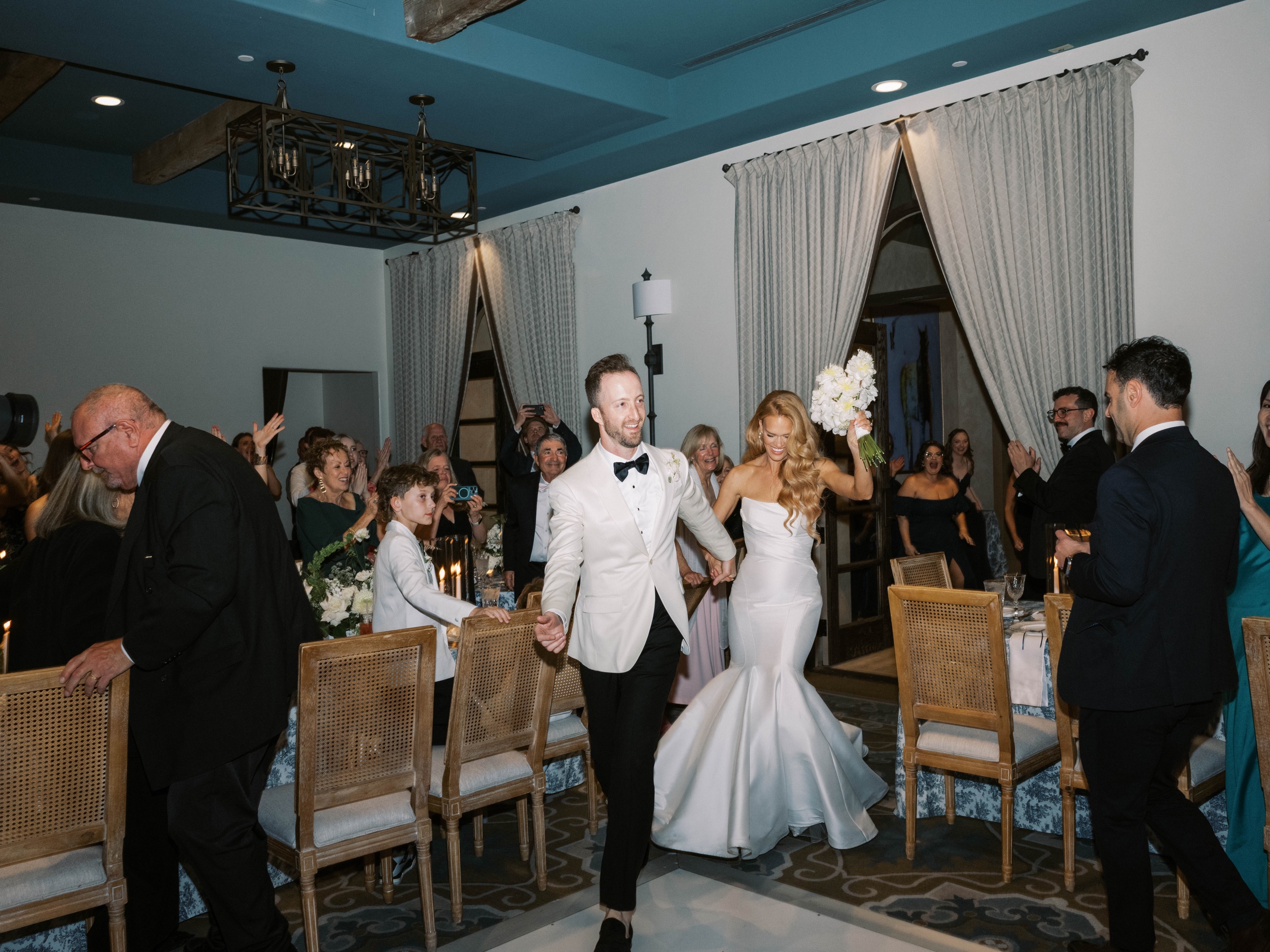 Meg and Peter enter their reception as guests applaud
