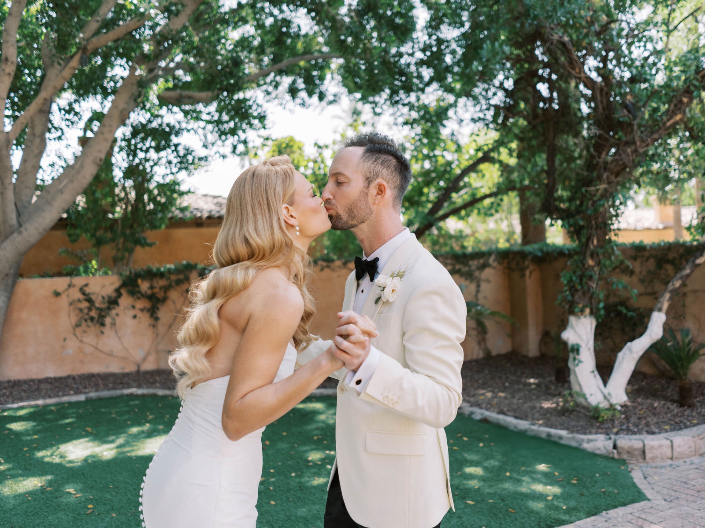 Meg and Peter kiss beneath the trees during their first look