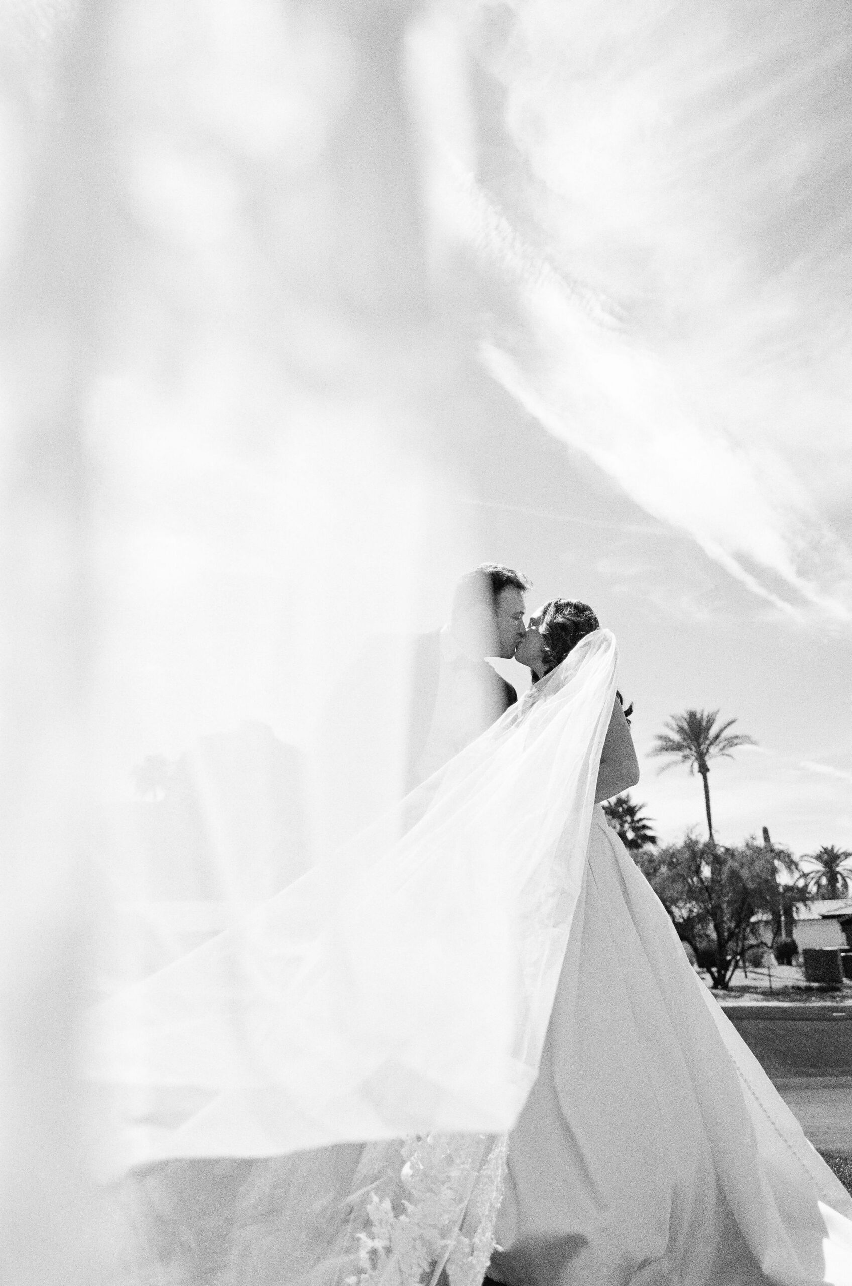 A black-and-white film portrait of Taylor and Ryan surrounded by her moving veil.