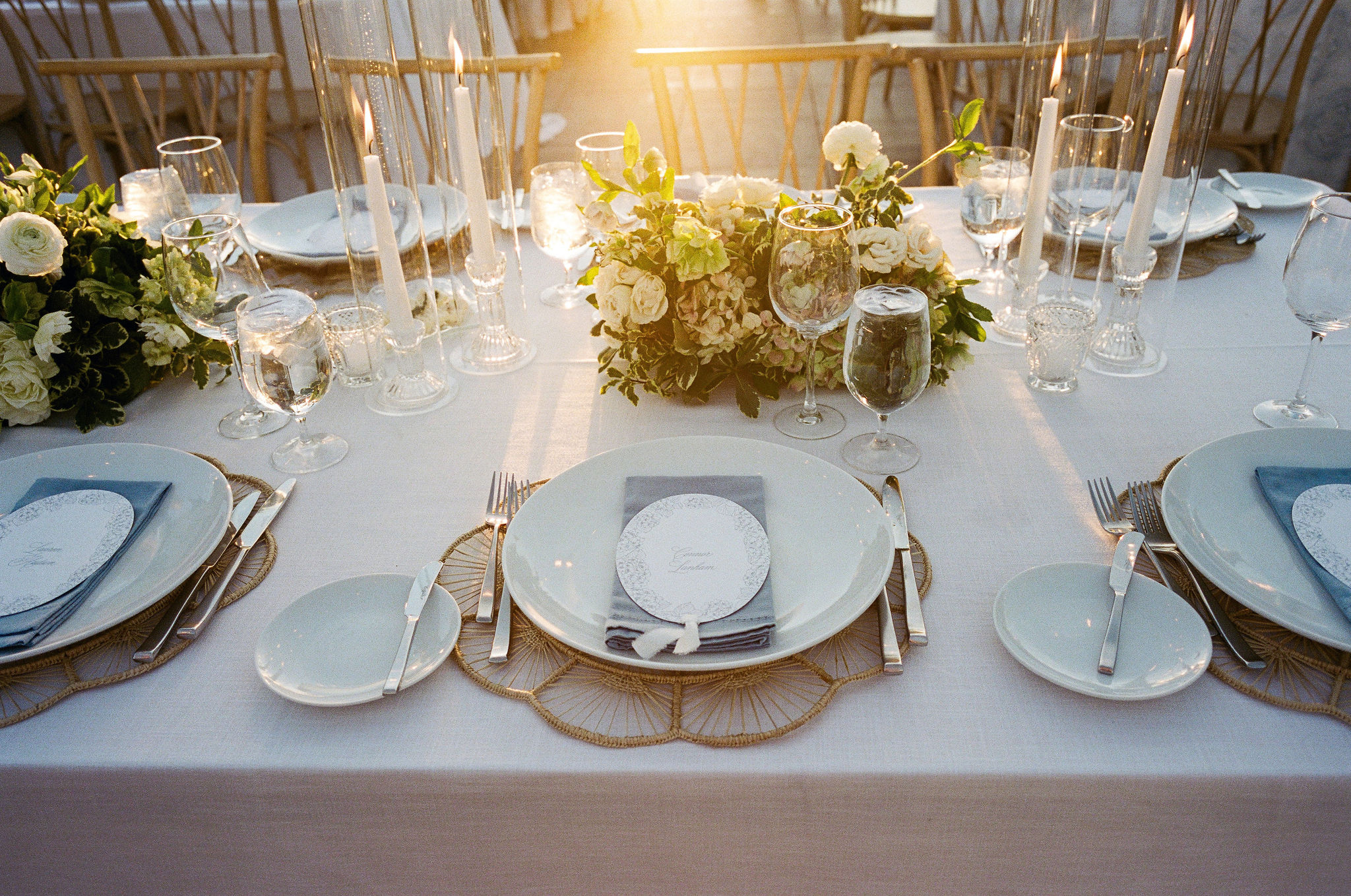 Sunlight falling across menus, glassware, and flowers on the reception table on film.