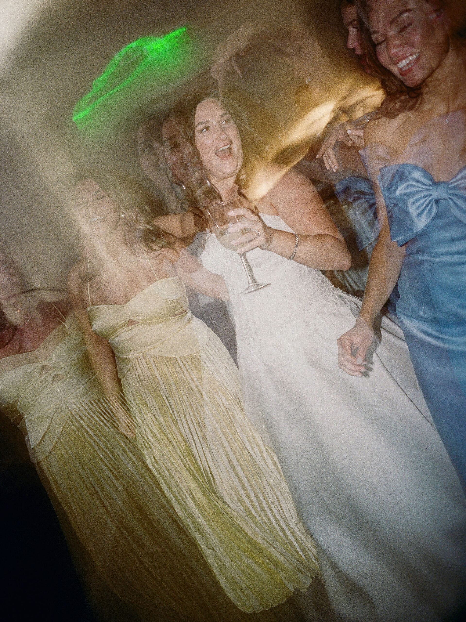 Taylor celebrating with friends amid motion and colored light on film.